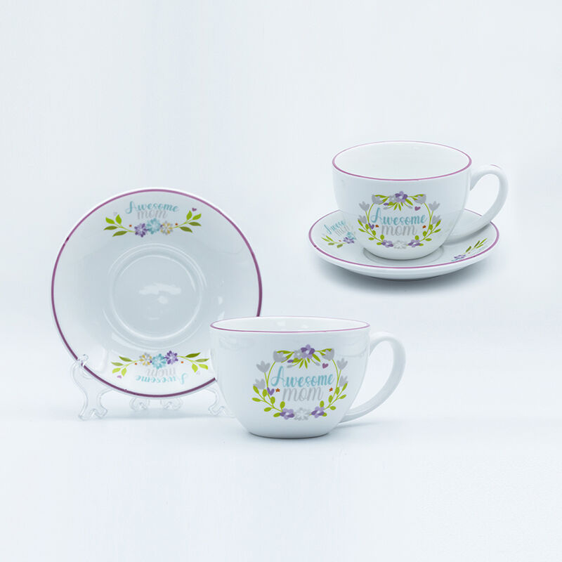 Die Tasse und Untertasse mit aufgebrachter Dekoration, gebrannt, Strichzeichnung des Henkels und farbiger Rand zum Muttertag.